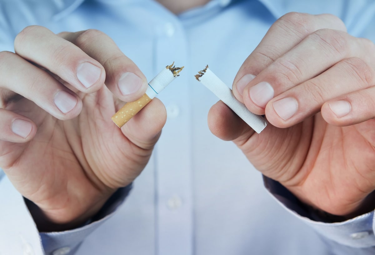 Человек ломает сигарету